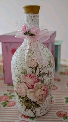 a vase with flowers painted on it sitting on a table next to a pink box