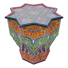 an elaborately painted wooden table with intricate designs on the top and sides, isolated against a white background