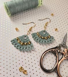 a pair of scissors sitting on top of a table next to some beads and thread