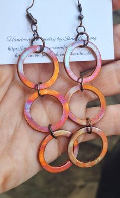 These rustic, boho style earrings feature 3 copper hoops 1" in diameter that have been fire painted using a propane torch to bring out the different colors in the metal when heated. NOTE:  Certain lighting will bring the colors out more than other types of lighting. These earrings measure just under 4" in length.  They will ship in a gift box or bag via USPS with tracking info provided. Nickel-free Copper Artsy Jewelry, Multicolor Round Copper Jewelry, Artsy Nickel-free Copper Jewelry, Unique Nickel-free Copper Hoop Earrings, Unique Hand Painted Copper Jewelry, Adjustable Artsy Nickel-free Hoop Earrings, Unique Hand-painted Copper Jewelry, Adjustable Circular Copper Jewelry, Bohemian Hand-painted Copper Jewelry