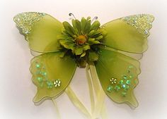 a close up of a green flower with glitters on it's petals and wings