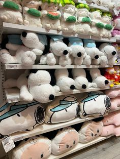 many stuffed animals are on display in a toy store, and one is white with black eyes