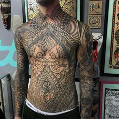 a man with lots of tattoos on his body and chest is looking at the camera