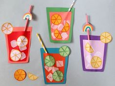 four paper cups with straws, orange slices and lemonade on the sides are cut out to look like fruit