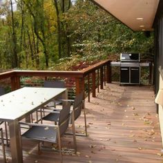 an outdoor deck with table, chairs and grill