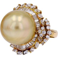 The allure of golden radiance captured in a singular, timeless design—this cocktail ring is a story told in the language of elegance and luxury. At its heart lies an exquisite Golden South Sea pearl, an opulent 15.5 mm sphere of natural luster that seems to glow with the warmth of a thousand sunsets. Surrounding this gem of the sea, a glittering embrace of 2.39 carats of sparkling diamonds forms a dazzling halo, each diamond carefully placed to amplify the beauty of the pearl. The diamonds, mast Expensive Jewlery, Yellow Gold Cocktail Ring, Glow Jewelry, Gucci Rings, Big Board, Pearl Rings, Golden South Sea Pearls, Pearl And Diamond Ring, Gold Cocktail Ring