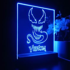 a blue neon sign with an image of a demon on it and the word venom written in white