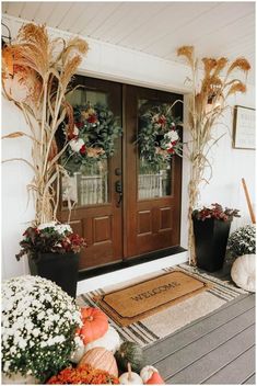 front door decorated for fall with wreaths and pumpkins