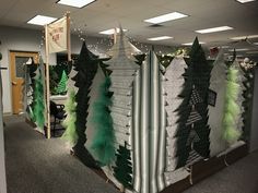 an office cubicle decorated with green and white christmas trees