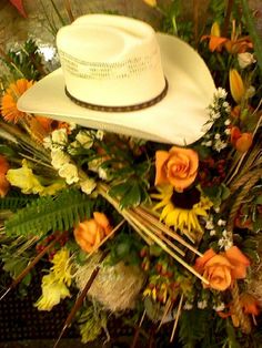 a white cowboy hat surrounded by flowers and plants