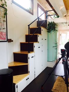 a camera is set up to take pictures of some stairs in a house with white walls and wood floors