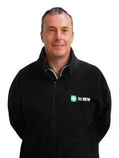 a man wearing a black jacket with the irish flag on it, standing in front of a white background