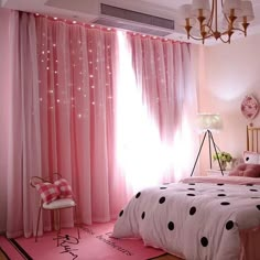 a bedroom decorated in pink and black with polka dots on the comforter, curtains, and bedding