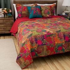 a bed with colorful comforter and pillows in a bedroom