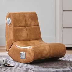 a brown reclining chair sitting on top of a rug next to a remote control