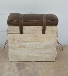 three wooden boxes stacked on top of each other with brown leather straps around the edges