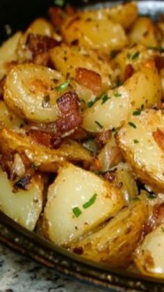 cooked potatoes with bacon and parsley in a glass dish on a granite countertop