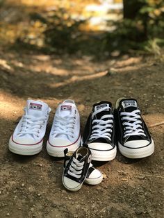 three pairs of black and white converse shoes sitting on the ground next to each other