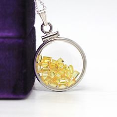 "Vibrant handcrafted brand new sterling silver genuine yellow sapphire shaker locket! This radiant pendant is dime sized with coin style bezels, and clear lucite covers. The round charm showcases genuine fancy sapphires in bright yellow hues. There is an estimated 2.5 CTW of faceted baguette cut sapphires sparkling within the double sided locket's clear lucite covers. A gorgeous piece of brand new gemstone jewelry, featuring beautiful genuine gems! ERA - New METAL / MATERIAL - Sterling silver lo Sterling Silver Yellow Charms Jewelry, Yellow Sterling Silver Charms Jewelry, Amber Jewelry With Polished Finish As Gift, Amber Polished Finish Jewelry For Gifts, Polished Amber Jewelry For Gift, Nickel-free Yellow Round Pendant Jewelry, Yellow Sapphire Jewelry Gift, Yellow Sapphire Jewelry For Gift, Amber Pendant Locket Jewelry