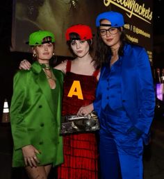 three women standing next to each other in front of a movie poster at an event