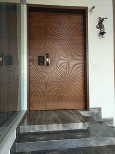 a wooden door with an intricate design on the side and steps leading up to it