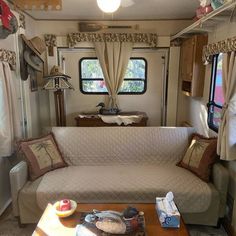 a living room filled with furniture next to a kitchen and dining area in a mobile home