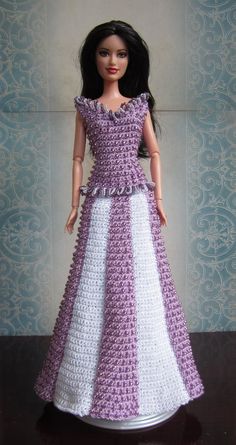 a doll wearing a dress made out of crocheted material on top of a table