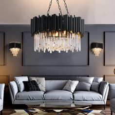 a living room filled with furniture and a chandelier hanging over the couches