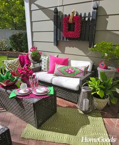 a patio with wicker furniture and colorful pillows