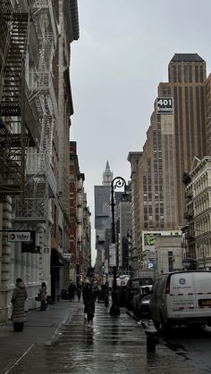 people are walking down the street on a rainy day