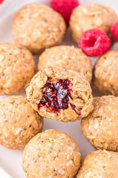 some raspberry oatmeal cookies are on a white plate with berries