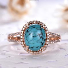 an oval turquoise stone surrounded by white and brown diamonds on top of a pink gold band