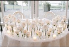 a table with white flowers and candles on it