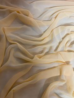 an image of a bed that is made up with white sheets and yellow ruffles