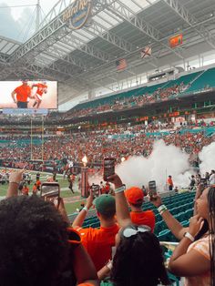 fans at a football game taking pictures with their cell phones