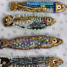 three pieces of beaded jewelry sitting on top of a white cloth covered tablecloth