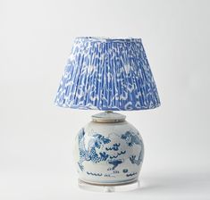 a blue and white vase with a lamp on it