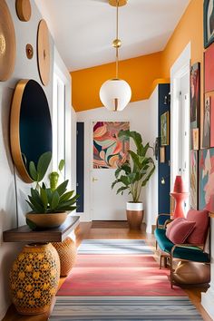 a hallway with colorful rugs and art on the walls, potted plants in vases