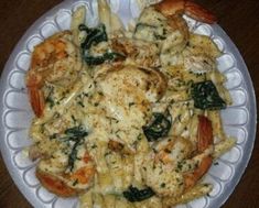 a white plate topped with pasta and shrimp