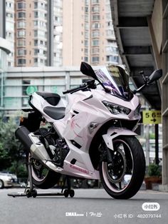 a white motorcycle parked on the street next to tall buildings