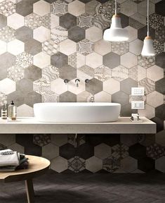 a bathroom with hexagonal tiles on the wall and a sink in the center