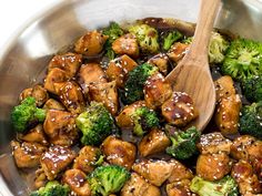 chicken and broccoli stir fry in a pan with a wooden spoon