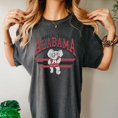 *Also available as a sweater. See below.* Kick it old school with our Retro Alabama T-Shirt! This stylish tee combines a vintage look with your love for Alabama football. Show off your team spirit in a quirky and fun way. Go team! Retro Game Day T-shirt With Team Name, Retro Team Name T-shirt For Fans, Retro Team Name T-shirt For Game Day, Retro T-shirt With Team Name For Fans, Retro T-shirt With Team Name For Fan Gear, Vintage Team Logo T-shirt For Fans, Retro Game Day T-shirt For Football Season, Vintage Graphic Print Football T-shirt, Vintage Graphic T-shirt For Football Season