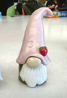 a ceramic figurine with a strawberry on it's head sitting on a table