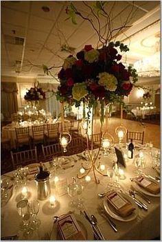 the centerpiece is surrounded by candles, flowers and wine glasses for an elegant wedding reception