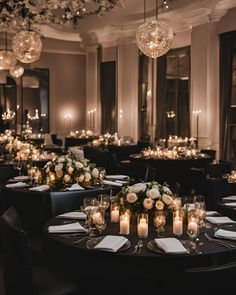 the tables are set with candles and centerpieces for an elegant wedding reception at night