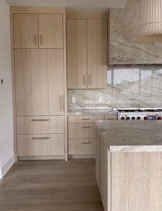 a kitchen with wooden cabinets and marble counter tops