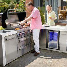 a man and woman are cooking on an outdoor grill