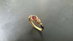 This stunning 14k gold ring is as unique as it is beautiful. Its inspired from an original Georgian band. It features a very fine quality 6X4mm genuine ruby and two high quality genuine diamonds totally .14 carats. The true uniqueness of this ring however is made obvious by the fine black enameling on the sides of the shank. Elegant Hallmarked Enamel Promise Ring, Unique Yellow Gold Enamel Ring For Anniversary, Elegant Engraved Enamel Ring, Unique 14k Yellow Gold Ruby Ring, Unique Yellow Gold Ruby Ring, Unique Yellow Gold Ruby Promise Ring, Elegant Red Rings For Ceremonial Occasions, Elegant Red Ceremonial Rings, Elegant Engraved Ruby Ring In Yellow Gold