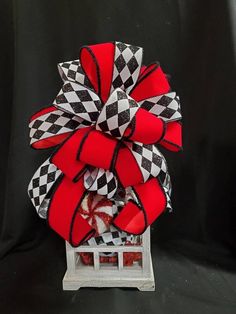 a red and black bow on top of a white box